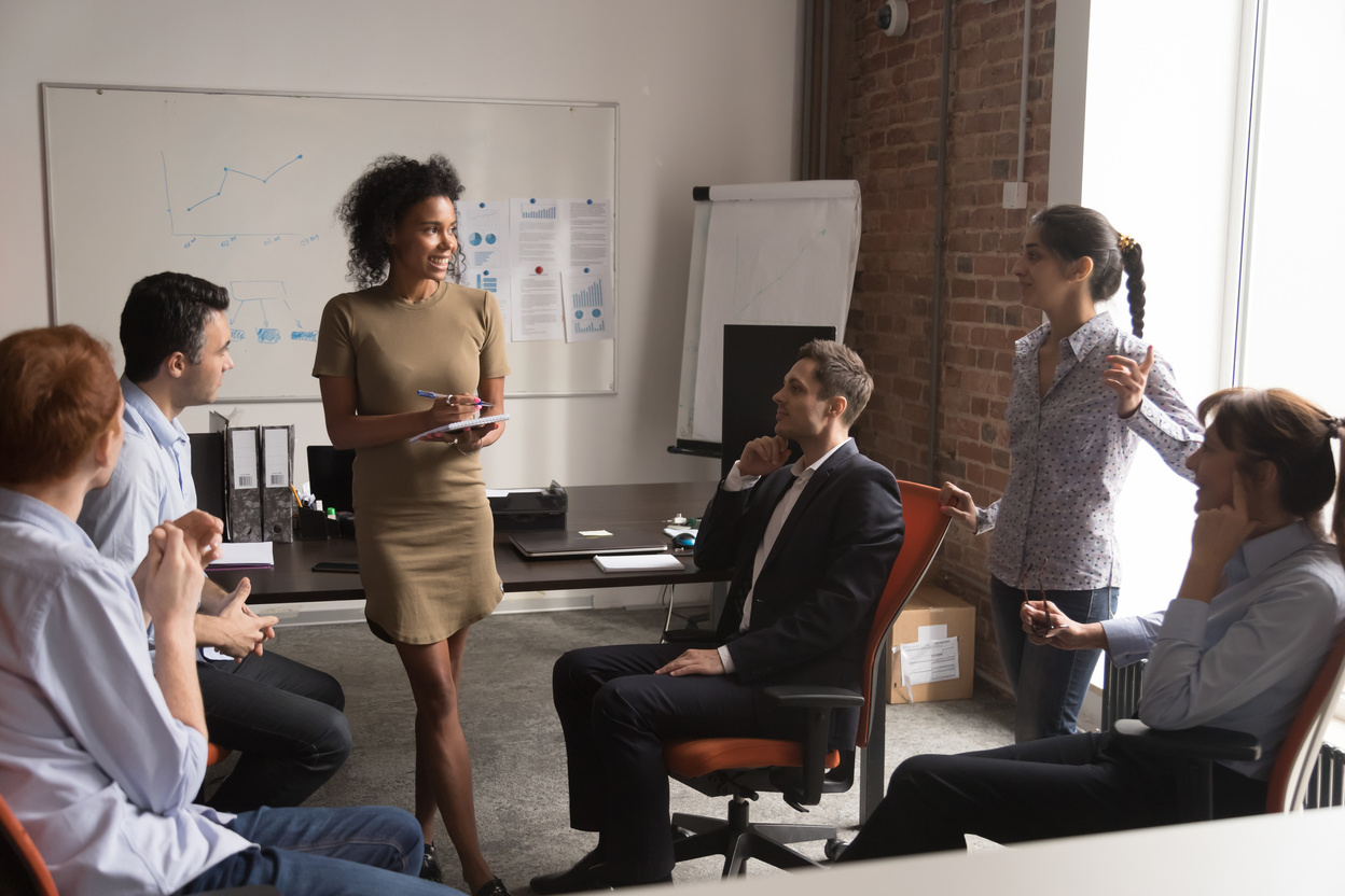 Diverse employees listening african business coach at corporate training